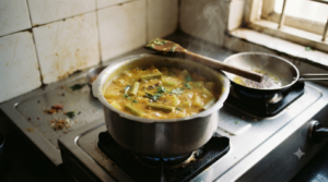 Sambar without pressure cooker simmering in an open pot with drumstick and toor dal