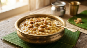 Sweet pongal with milk in a brass bowl with ghee-roasted cashews and raisins