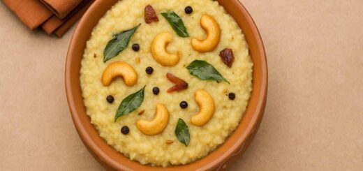 “Millet Pongal served in a terracotta bowl, garnished with cashews, curry leaves, peppercorns, and ginger pieces.”